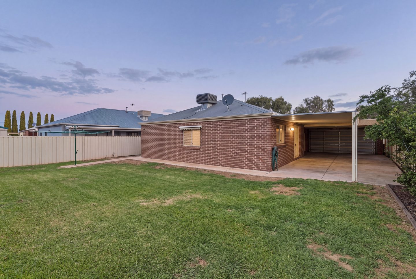 The rear facade and lawn at dusk